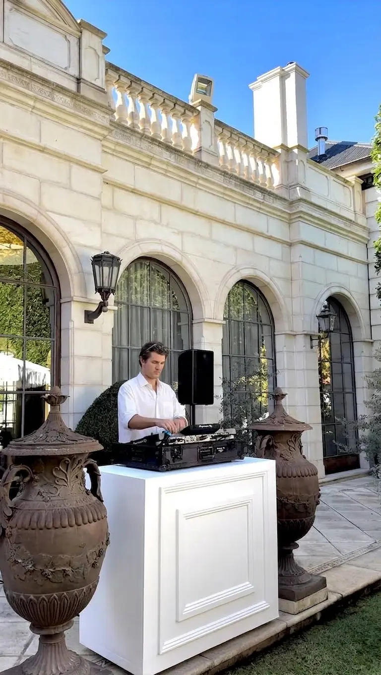 DJ de una empresa de sonorización trabajando en la cabina de una boda en una finca